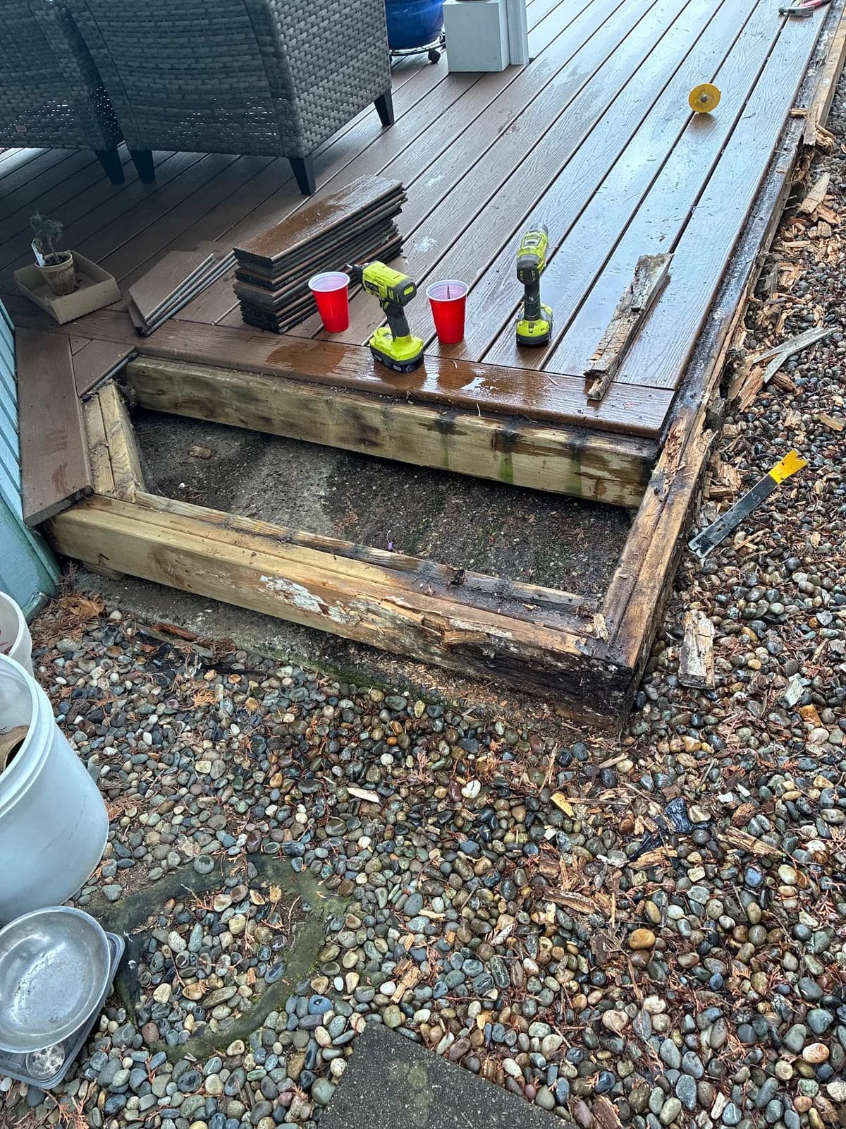 Deck step with the tread removed, exposing deteriorated wood framing