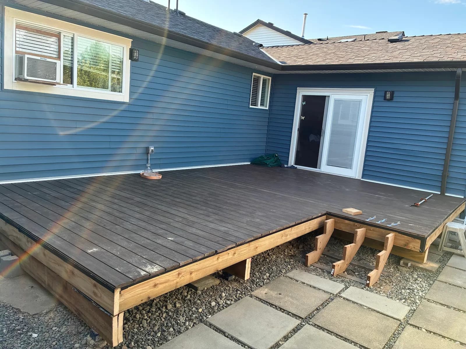 Brown decking installed over the frame, with the stair opening still unfinished